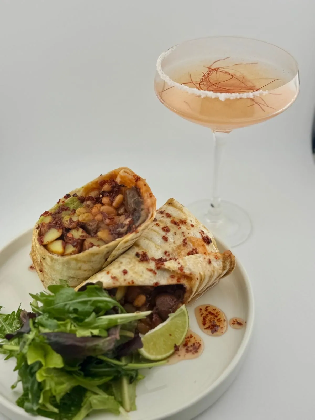 Burrito mit Gemüse-Quartett und Salat, daneben eine Spicy Margarita