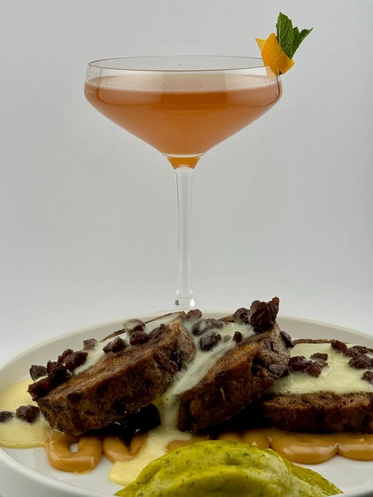 Serviettenknödel mit Vanillesauce, Espresso-Rosinen und Sorbet, daneben ein Pairing-Drink